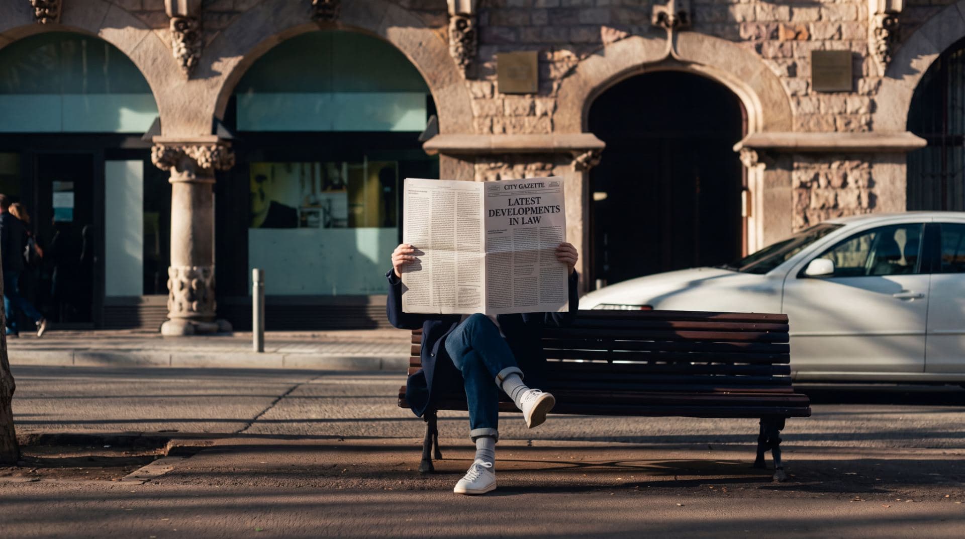 A person reading legal news in a city square
